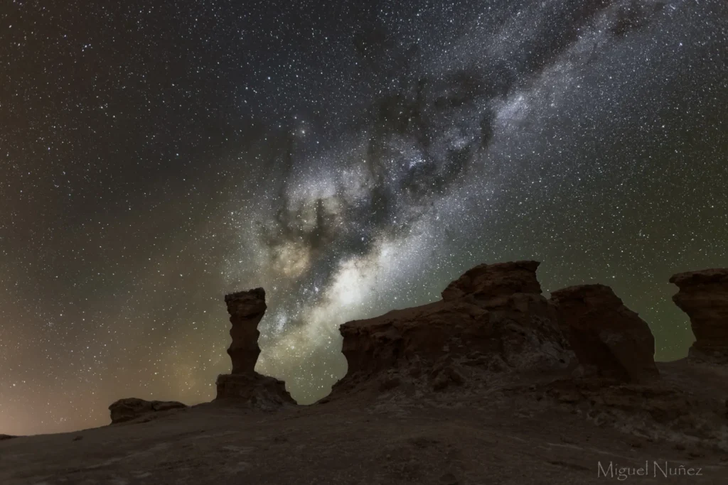fotografia de la via lactea en vallecito desierto de atacama, con rocas en primer plano y la vial lactea de fondo