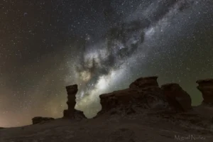 fotografia de la via lactea en vallecito desierto de atacama, con rocas en primer plano y la vial lactea de fondo