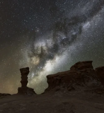 fotografia de la via lactea en vallecito desierto de atacama, con rocas en primer plano y la vial lactea de fondo